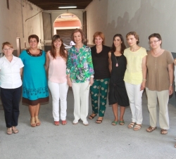 Fotografía de grupo de Su Majestad la Reina con coordinadoras y voluntarias del centro